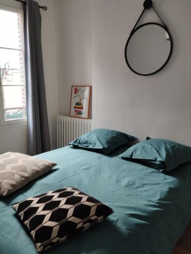 - une chambre avec un lit doté de draps verts et d'un miroir dans l'établissement Un Parfum D'embruns Hypercentre Honfleur, fibre, à Honfleur