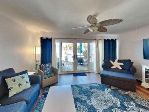 a living room with two couches and a ceiling fan at Sea Matanzas 2 in Saint Augustine