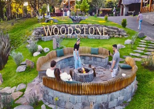 a group of people standing around a fire pit in a park at WoodStone Hotel Fazenda in Gramado