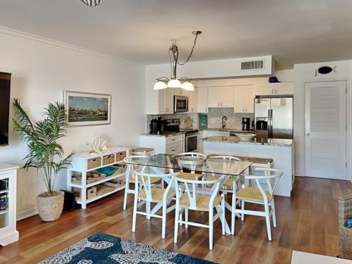 a kitchen and dining room with a glass table and chairs at Sea Matanzas 2 in Saint Augustine