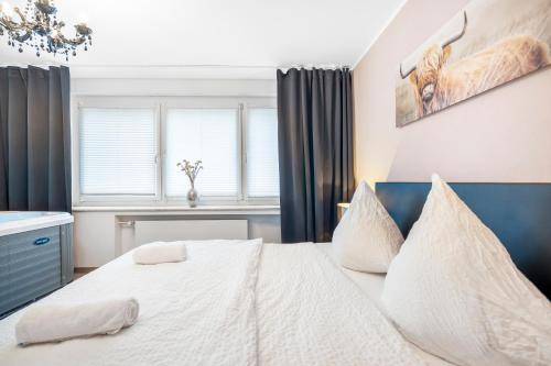 a bedroom with a bed with white sheets and pillows at Urban Retreat Apartment - Whirpool - Top Lage in Cologne