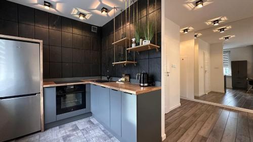 a kitchen with a refrigerator and a counter top at Apartament Skandynawski Sienkiewicza 13 in Kielce
