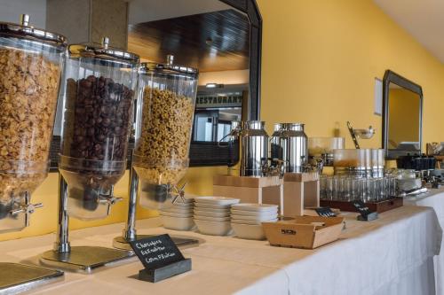 Sao Felix Hotel Hillside & Nature في بوفوا دي فارزيم: بوفيه مع اكواب الاكل على طاولة