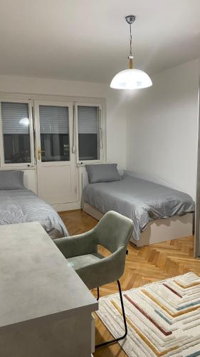 Una sala de estar con dos camas y una silla. en Modern City Apartment, en Bitola