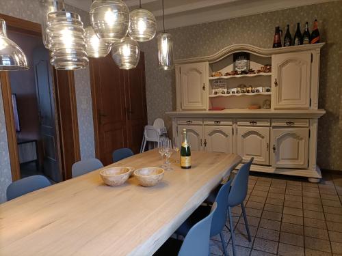 a kitchen with a large wooden table with bottles of wine at Moodraz vakantiehuis centrum Peer in Peer