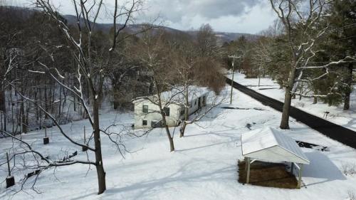 a snow covered yard with a house and a building at Time to Wine Down - Family Home in Afton