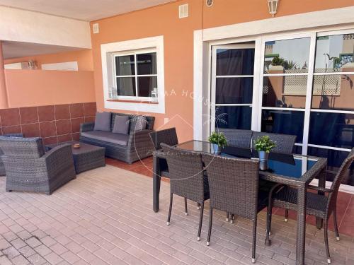 a patio with a table and chairs and a couch at Calma House in Caleta De Fuste
