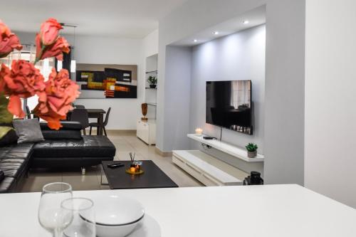 a living room with a couch and a tv at BH - Three Bedroom Apartment in Sliema