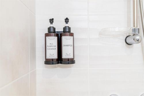 Deux bouteilles d'odorisants assises sur une étagère dans une salle de bains dans l'établissement Le Clair de Ville, à Pau