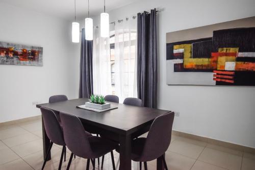 a dining room with a black table and chairs at BH - Three Bedroom Apartment in Sliema