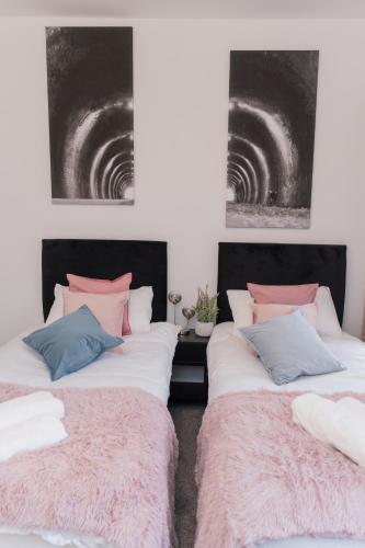 two beds sitting next to each other in a room at Entire home in Staffordshire in Stafford