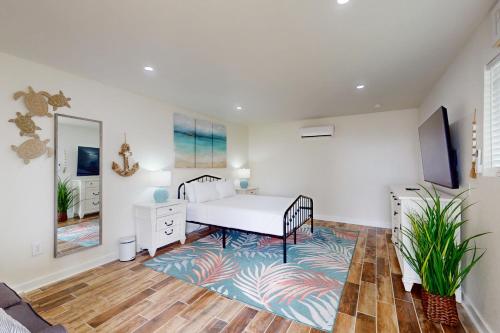 a bedroom with a white bed and a rug at Bella Vista & Four Winds House in Padre Island