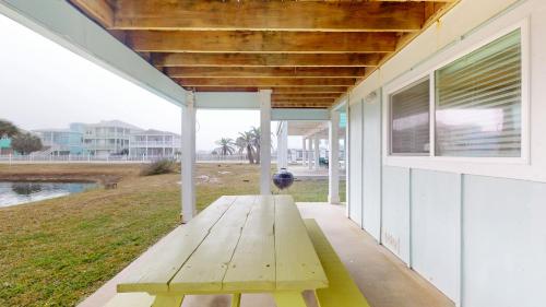 a wooden bench on the porch of a house at Bella Vista & Four Winds House in Padre Island
