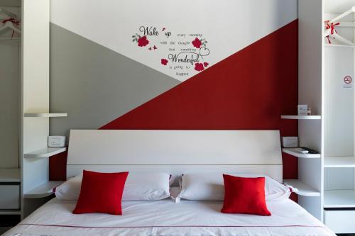 a bedroom with a white bed with red pillows at La terrazza sulle vigne B&B in Corte Franca