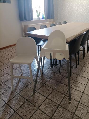 a dining room table with two white chairs and a table at Moodraz vakantiehuis centrum Peer in Peer