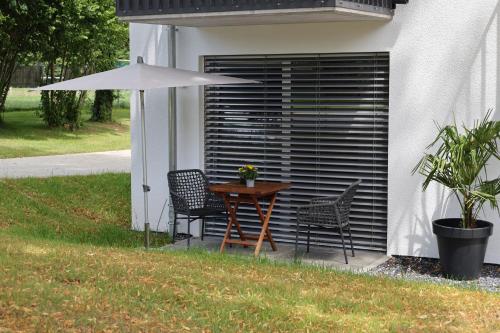 a table with two chairs and an umbrella in a yard at MEIN MOTEL - Self Check-in in Oberndorf am Neckar