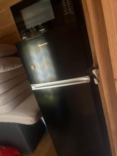 a small black refrigerator in a room with aermottermott at The Lodge in Penrydd