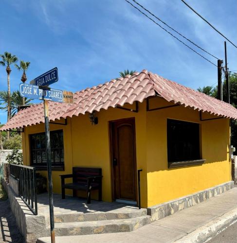 a yellow house with a street sign in front of it at Casa del Carmen, hermoso departamento en Loreto in Loreto