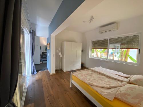 a bedroom with a bed and a window at Zweite Heimat - Townhouse Boa Vista in Sal Rei