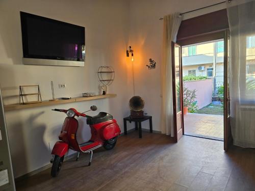 a red scooter parked in a living room with a tv at THAT'S LOVE Fiumicino Jazz in Fiumicino