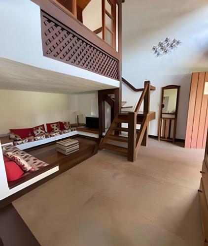 a room with a loft bed and a staircase at Linda casa com estilo buziana in Búzios