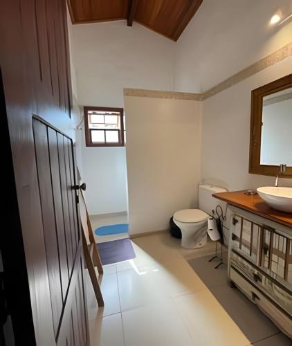 a bathroom with a toilet and a sink at Linda casa com estilo buziana in Búzios