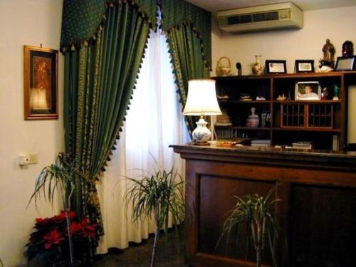 a living room with a window with green curtains at Hotel Astoria in Viareggio