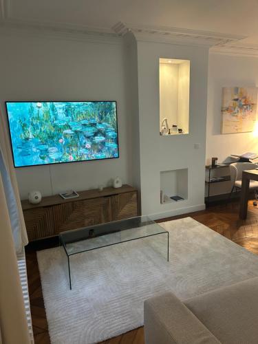 un salon avec une grande télévision à écran plat au mur dans l'établissement Typical Parisian flat Central Paris by Montmartre, à Paris