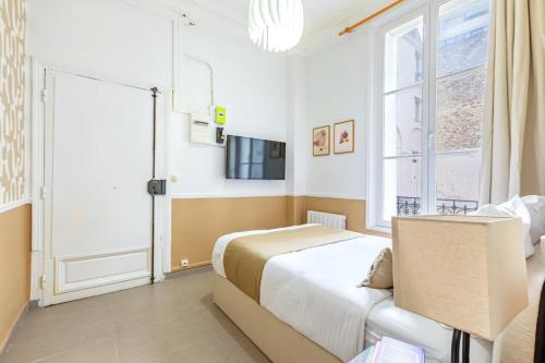 - une chambre avec un lit, une fenêtre et une télévision dans l'établissement Cozy Studio Paris Centre Montparnasse - II, à Paris