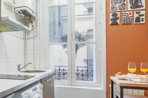 - une cuisine avec une fenêtre et 2 verres à vin sur une table dans l'établissement Cozy Studio Paris Centre Montparnasse - II, à Paris