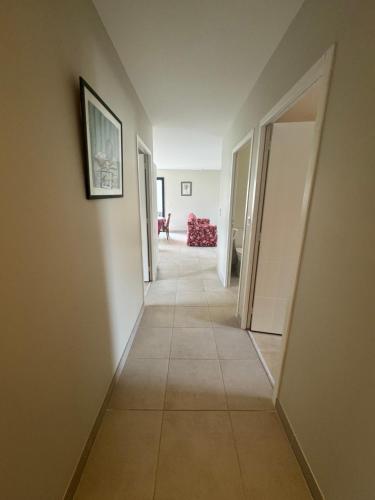a hallway with white walls and a tile floor at Villa " A 2 pas de la plage", maison plain-pied in Asnelles