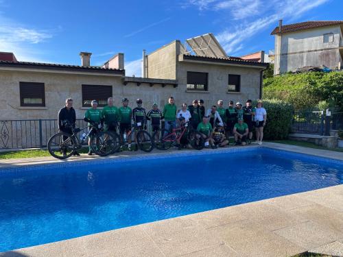 a group of people standing next to a swimming pool at Hotel Apartamento Marouco in A Guarda