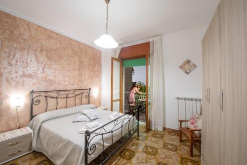 a bedroom with a bed and a woman looking out the window at Casa Ersilia in Agerola