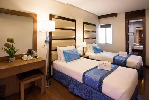 En eller flere senge i et værelse på Vieve Hotel