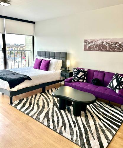a bedroom with a bed and a purple couch at Salt City Loft in Salt Lake City