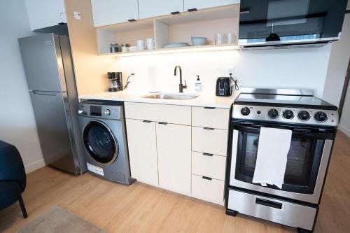 a kitchen with a stove and a sink and a dishwasher at Salt City Loft in Salt Lake City