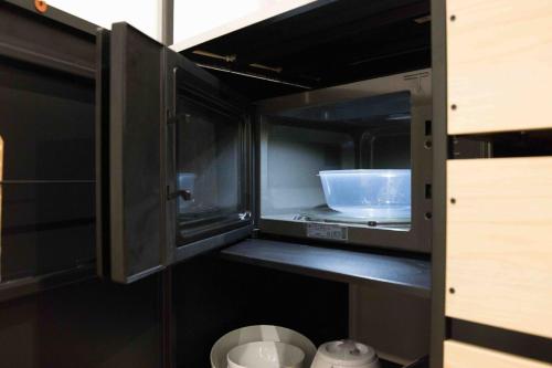 a kitchen with a microwave with a bowl in it at GUESTROOM Cosy in Arcueil in Arcueil