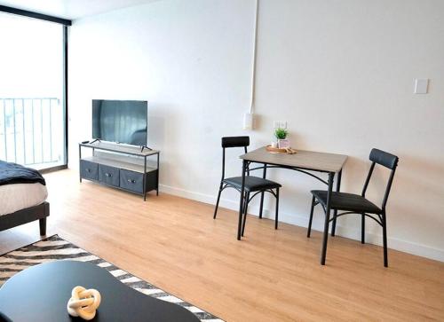 a living room with a table and chairs and a television at Salt City Loft in Salt Lake City