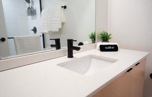 a white bathroom with a sink and a mirror at Salt City Loft in Salt Lake City
