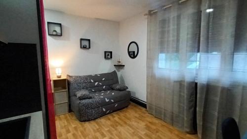 a living room with a chair and a window at Studio 18M2 proche de Vulcania in Pontaumur