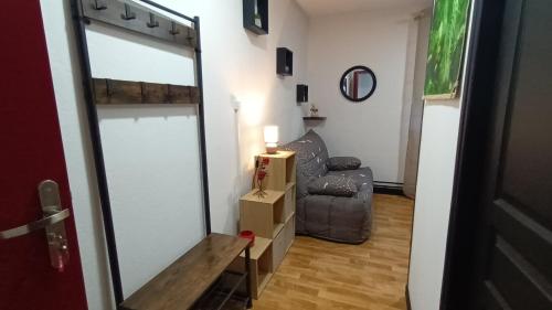 a living room with a chair and a mirror at Studio 18M2 proche de Vulcania in Pontaumur