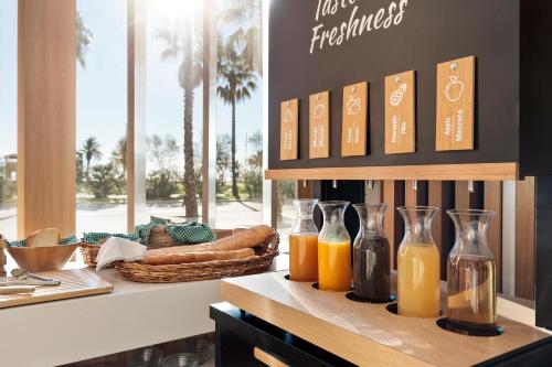 Un mostrador con tres botellas de vidrio de jugo de naranja. en Hotel Best Front Maritim, en Barcelona