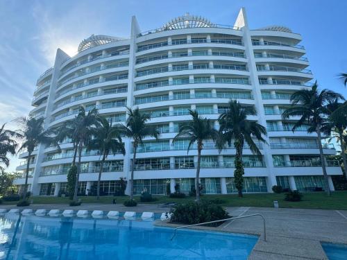 een groot gebouw met een zwembad ervoor bij Mayan Lake Horus in Acapulco