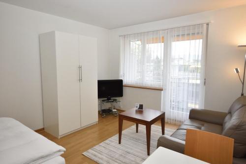 a living room with a couch and a tv and a table at Cozy studio in the city center - Mill 532 in Zürich