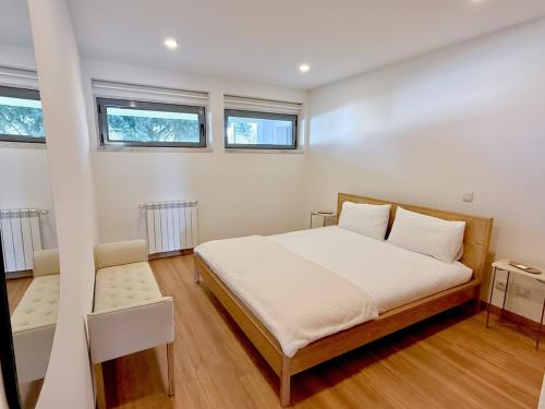 a bedroom with a large bed and two windows at Hygge Living Santa Cruz Beachfront in Santa Cruz