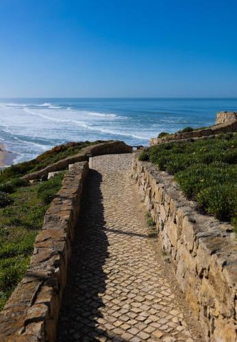 a stone path leading to the ocean on a beach at Hygge Living Santa Cruz Beachfront in Santa Cruz