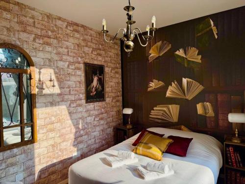 ein Schlafzimmer mit einem Bett und einer Ziegelwand in der Unterkunft Le Manoir des Sortilèges à Reims in Reims