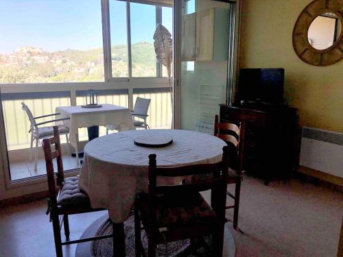 une salle à manger avec une table et des chaises et un balcon dans l'établissement Grand Studio proche cure&village, à Gréoux-les-Bains