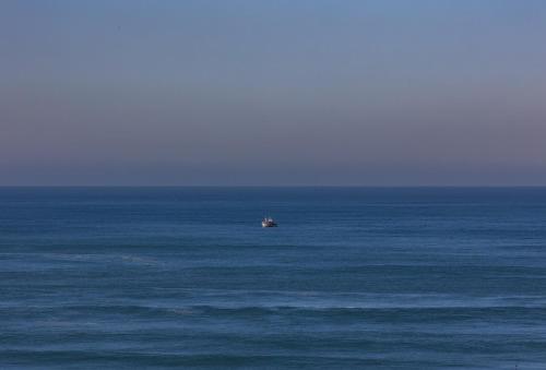a small boat in the middle of the ocean at Hygge Living Santa Cruz Beachfront in Santa Cruz