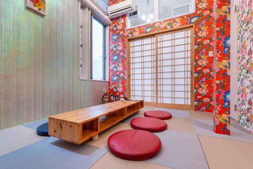 a room with a bench and red stools in it at Papillon Paradis Nishi-Shinjuku in Tokyo